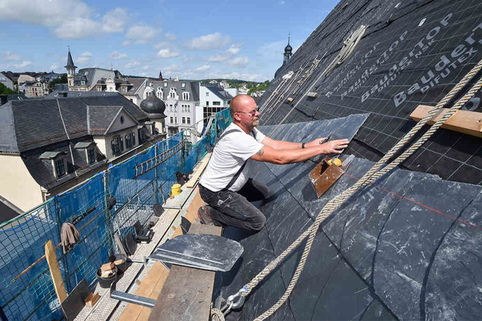 Joachim Viertel (59) ist der Stadtverwaltung aufs Dach gestiegen und deckt es mit neuen Schiefern ein.