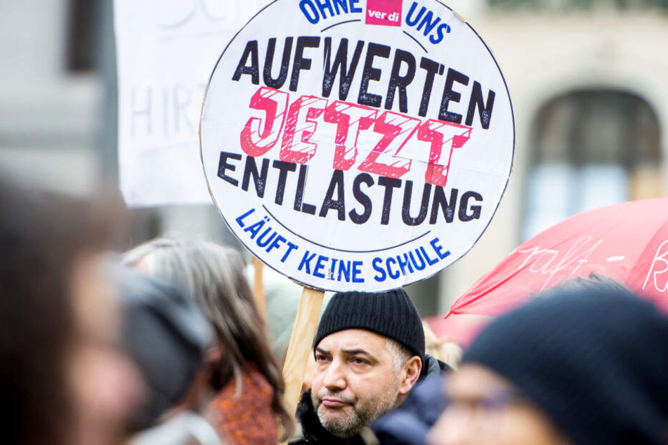 Ein Mann hält auf einer Kundgebung im Rahmen eines Warnstreiks am vergangenen Mittwoch in Hamburg ein Schild mit der Aufschrift "Ohne uns läuft keine Schule - Aufwerten jetzt - Entlastung".