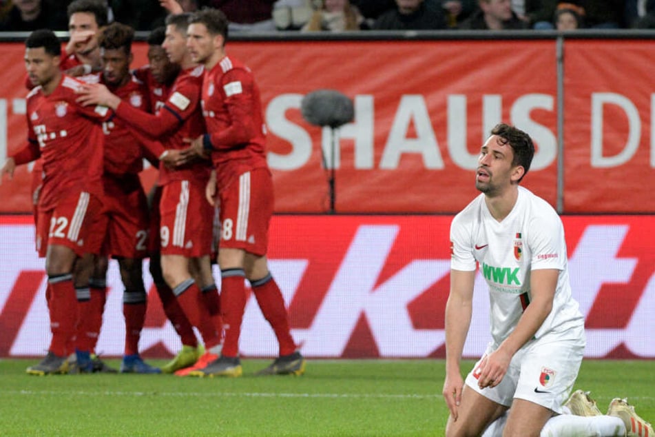 Rani Khedira (r) kniet auf dem Rasen, während die Spieler von München über das 2:3 jubeln.
