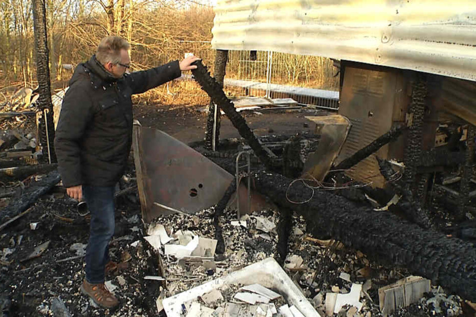 Besitzer Gerd Helmchen (49) vor einem Haufen Schutt und Asche, der mal sein "Eiscafé Sunset" war.
