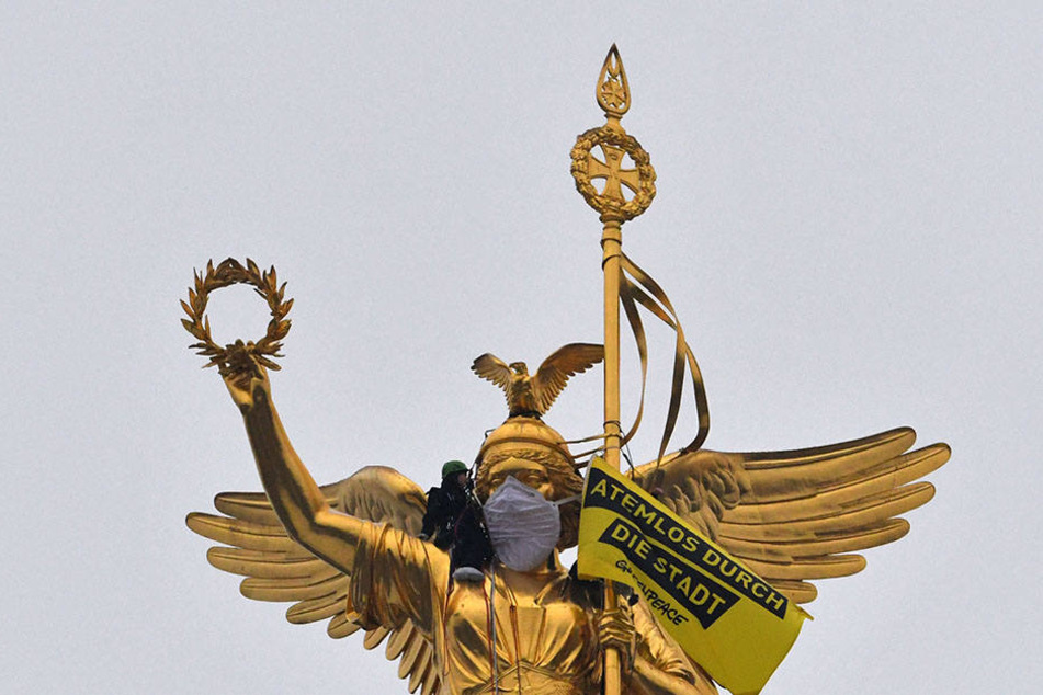 Greenpeace-Aktivisten überziehen der Statue auf der Siegessäule in Berlin eine Atemschutzmaske. Unter dem Motto "Atemlos durch die Stadt" protestierten sie gegen die Stickoxidbelastung in den Innenstädten.