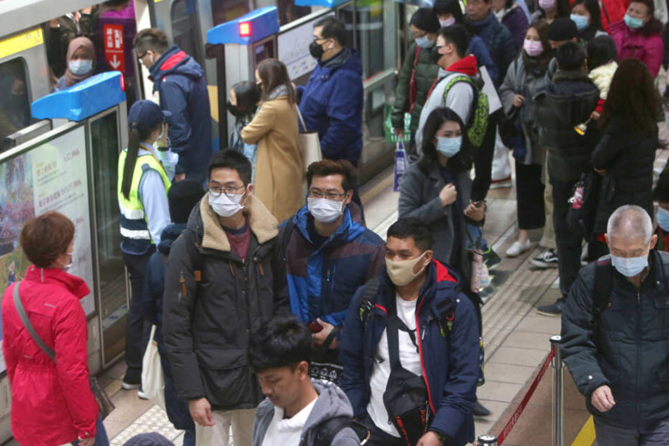 Passagiere in Taiwan tragen Mundschutz in einer U-Bahn-Station.