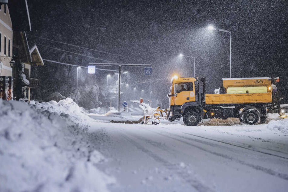 Ein Räumfahrzeug schiebt in St. Johann Im Walde Schnee von einer Strasse.