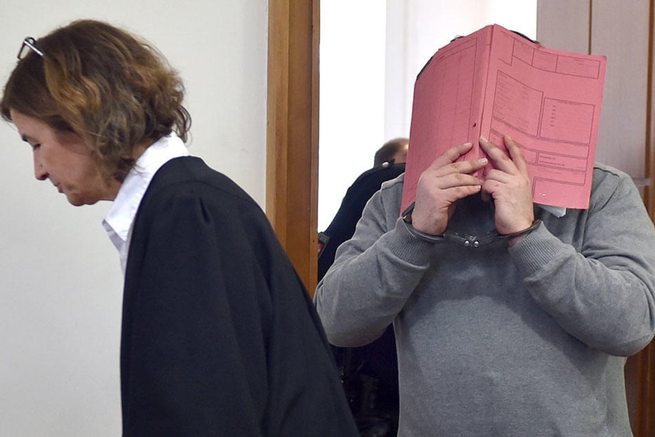 Der ehemalige Krankenpfleger Niels H. versteckt sein Gesicht hinter einem Aktendeckel.