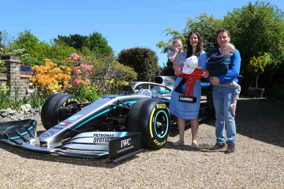 Harrys Schwester Georgia, Mutter Charlotte, Vater James neben einer Nachbildung des Rennwagens von Lewis Hamilton. Harry Shaw hatte seinem Idol Hamilton in einer Nachricht viel Glück für das Rennen in Spanien geschickt. Hamilton antwortete ihm.