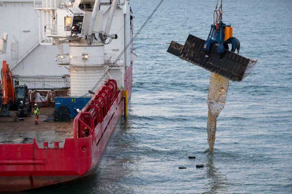 Der Bergungsschiff hebt einen zerstörten Container vom Nordseegrund.