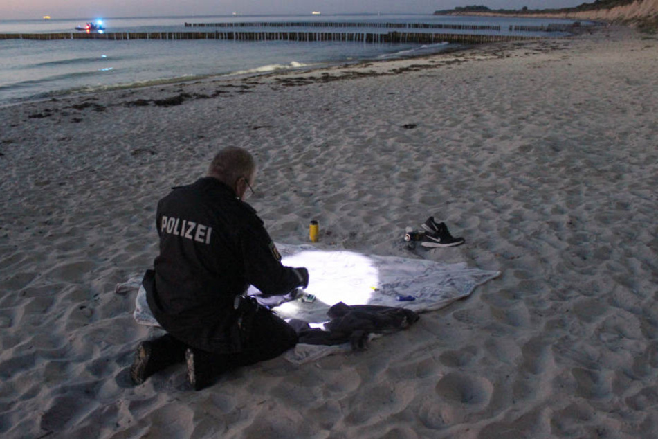 Ein Beamter untersucht die zurückgelassenen Kleidungsstücke.