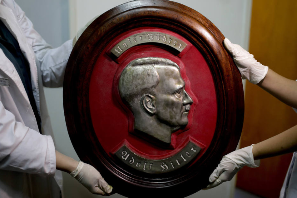 Mitarbeiter der Bundespolizei zeigen in Argentinien ein Relief von Adolf Hitler.