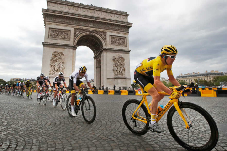 Eine Gruppe Radsportler fährt während der Tour de France am Arc de Triomphe in Paris vorbei.
