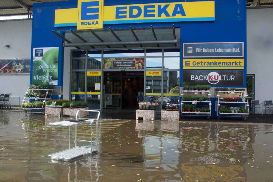 Hier steht der Eingang eines Supermarktes in Tamm unter Wasser.