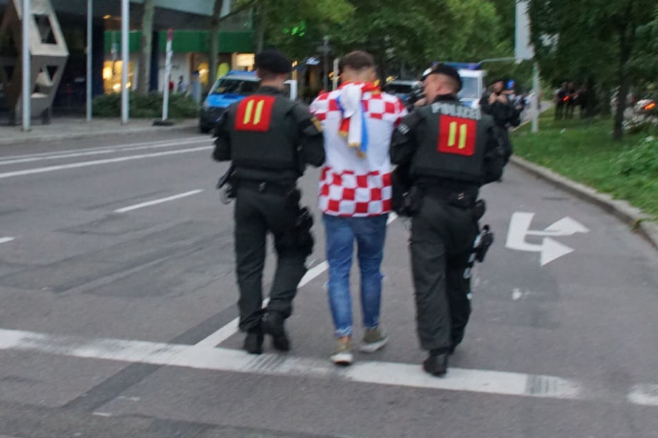 Polizeibeamte führen einen kroatischen Fan ab.