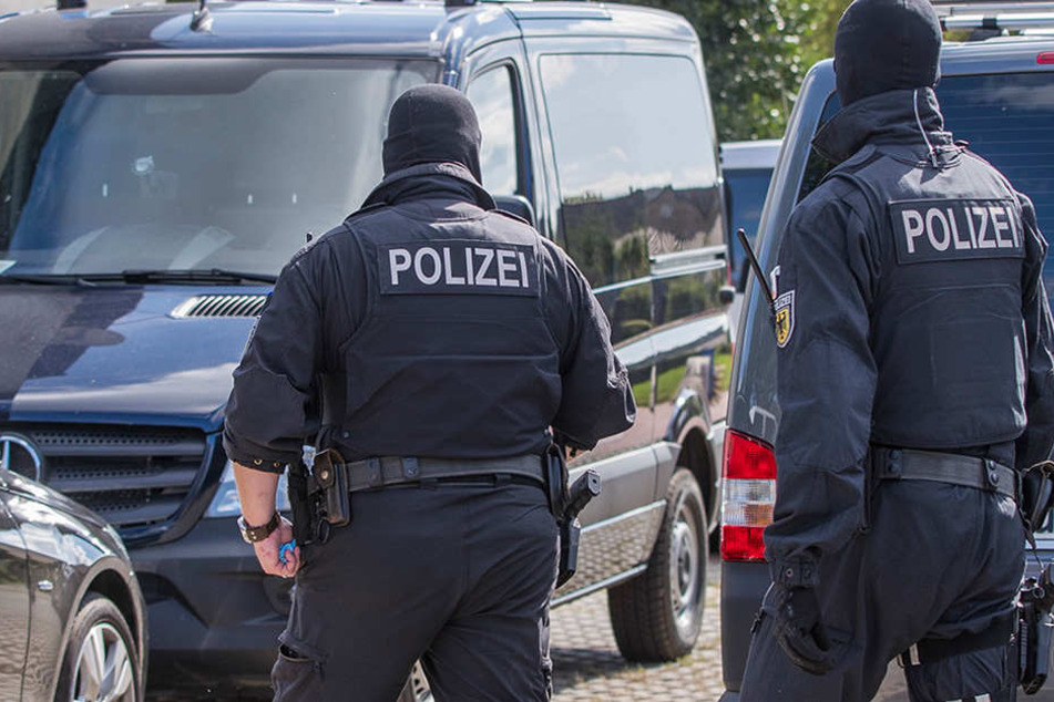 Polizisten einer Spezialeinheit gehen auf ein Grundstück in Banzkow (Mecklenburg-Vorpommern).