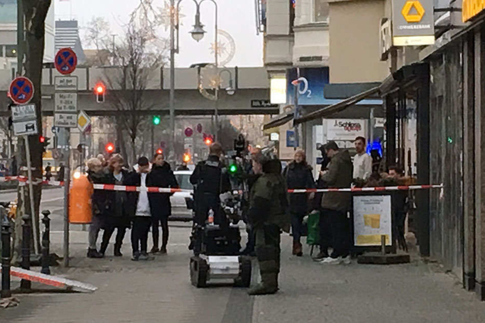 Ein Polizist und ein Sprengstoffroboter stehen vor der Bankfiliale in der Schlossstraße.