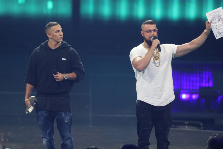 Der Rapper Kollegah hält eine Karrikatur von Sänger Campino mit Heiligenschein hoch.