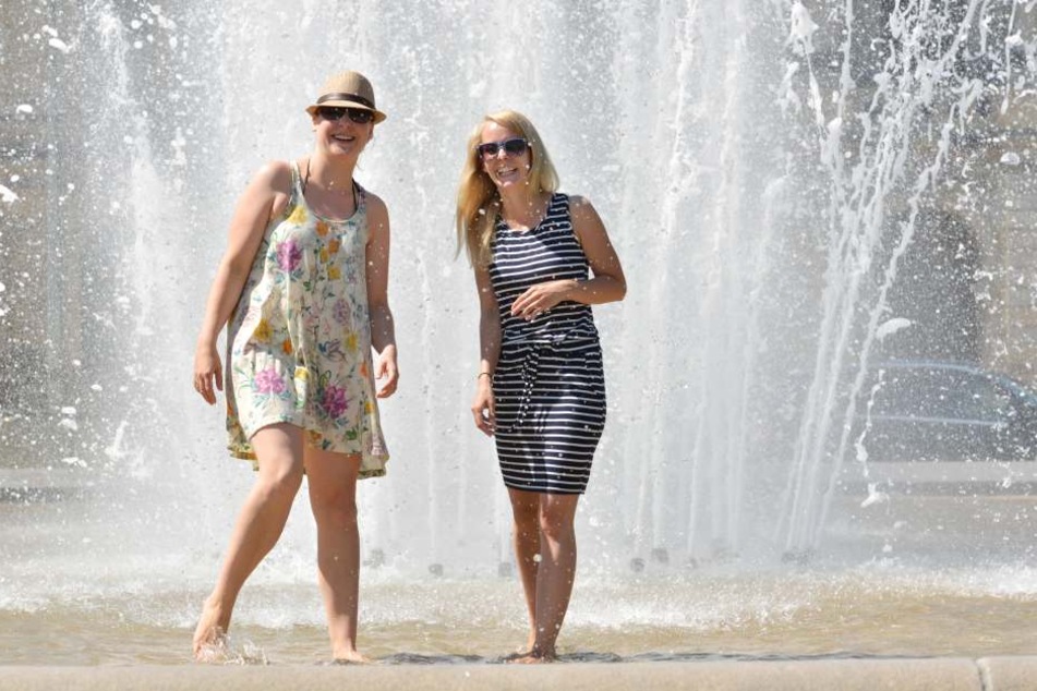 Susanne Heber (33) und Susanne Otto (29) erfrischen sich bei der Hitze im
Brunnen am Palaisplatz.