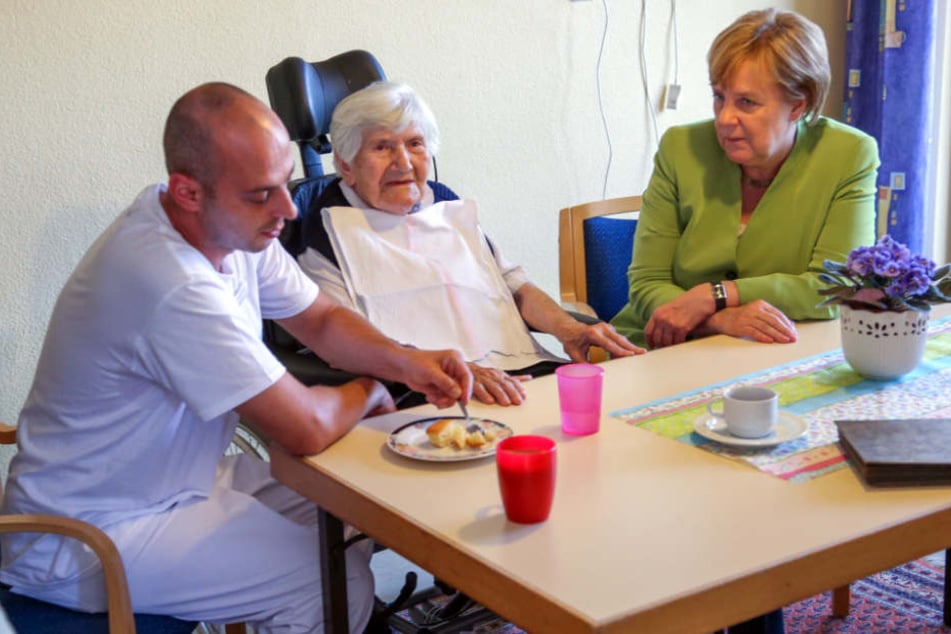 Die Bundeskanzlerin begleitet Ferdi Cebi (links) bei seiner Arbeit.
