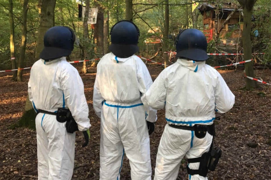 Die Polizisten haben Schutz-Anzüge wegen der Fäkal-Attacken angelegt.