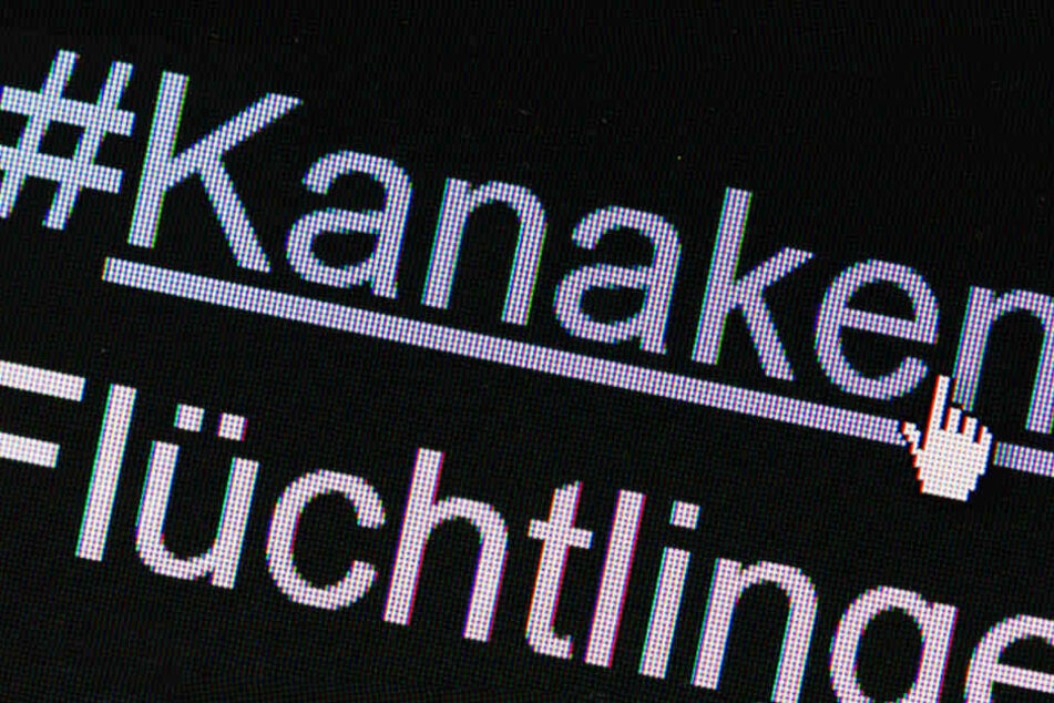 Der Hashtag "#Kanaken" auf einem Bildschirm über dem Schriftzug "Flüchtlinge" in Berlin auf einem Computer zu sehen.