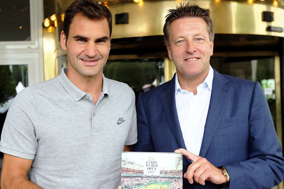 Ankunft von Tennis-Superstar Roger Federer (links) bei den GERRY WEBER OPEN! Zur Begrüßung überreichte Turnierdirektor Ralf Weber ein in Acryl eingefasstes Turnierplakat als Retromotiv.