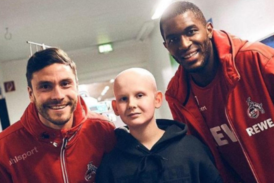 Jonas Hector (links) und Anthony Modeste (rechts) posieren mit einem kleinen FC-Fan.