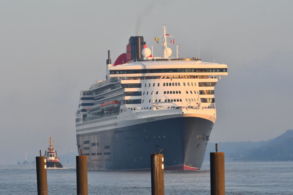 Die Queen Mary 2 gleitet im Morgengrauen die Elbe in Richtung Hamburg entlang.