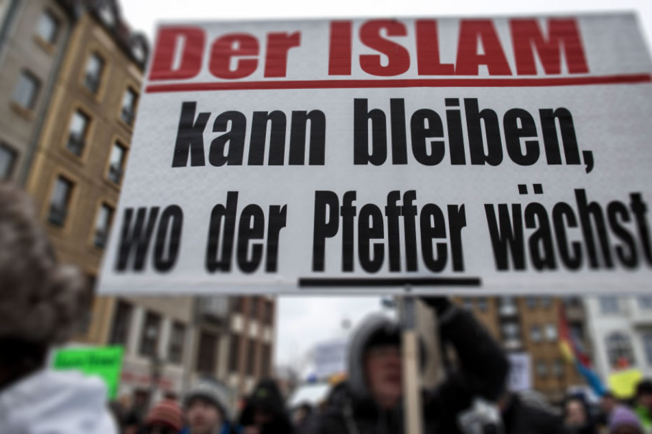Teilnehmer der Demonstration des Bürgervereins "Zukunft Heimat" gegen Flüchtlinge tragen ein Transparent mit der Aufschrift "Der Islam kann bleiben, wo der Pfeffer wächst!"