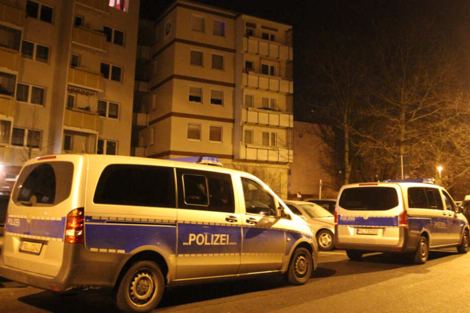 Vor dem Mehrfamilienhaus stehen zwei Polizeiwagen.