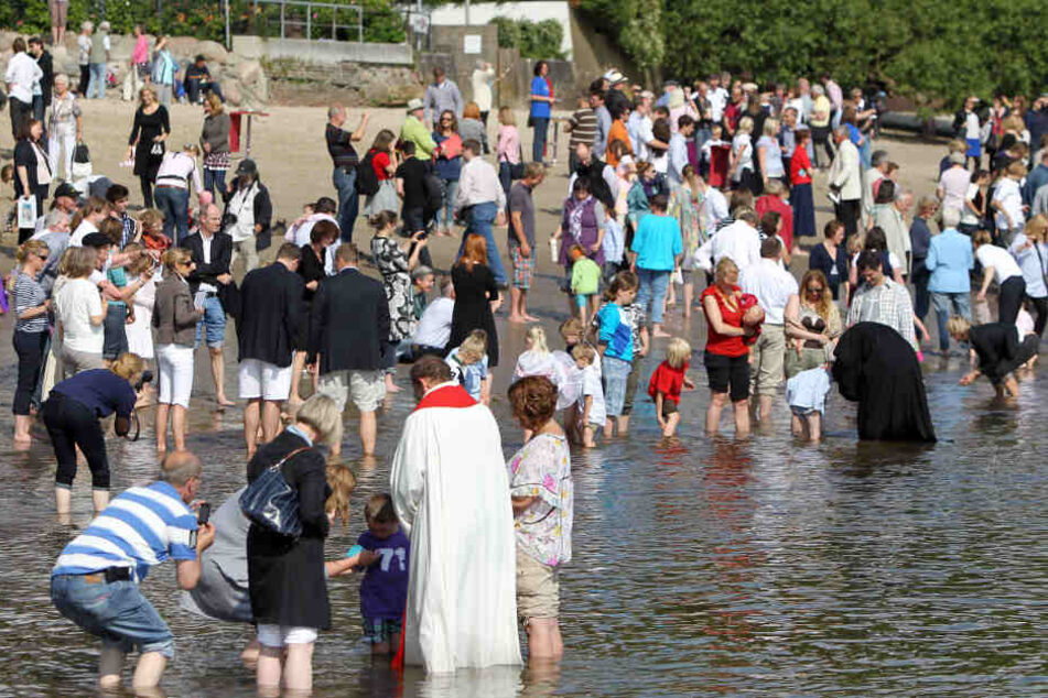 Kinder werden an der Elbe in Hamburg getauft. Zum Elbtauffest werden am Pfingssamstag 500 Täuflinge erwartet.