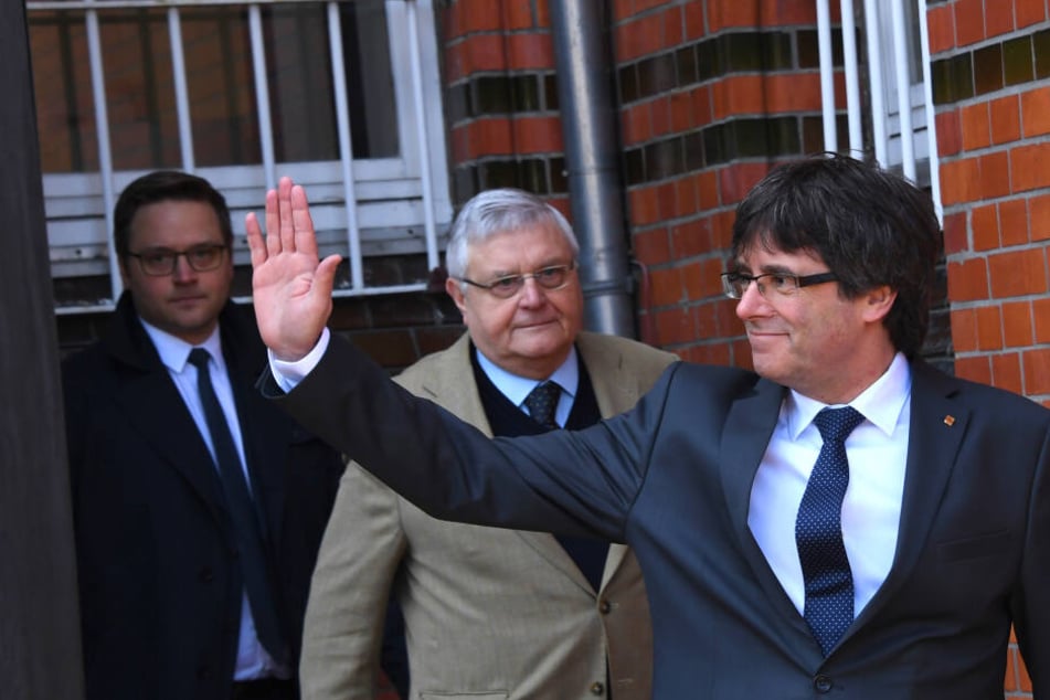 Carles Puigdemont, ehemaliger Präsident der spanischen Region Katalonien, als er mit seinen Anwälten aus der JVA Neumünster kommt und winkt.