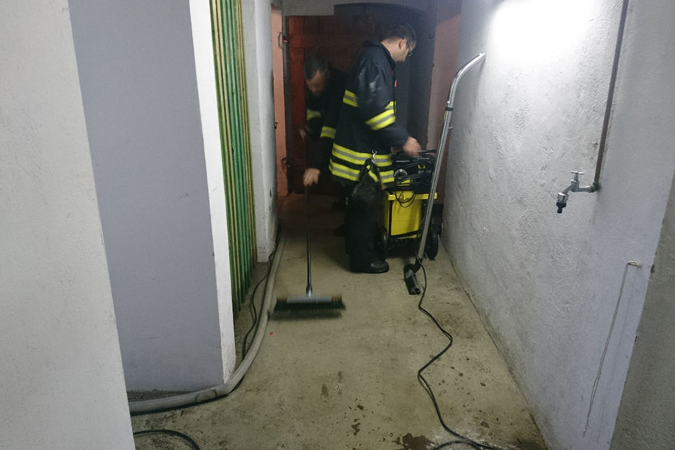 Feuerwehrmänner saugen das Wasser aus einem Keller in Erfurt.