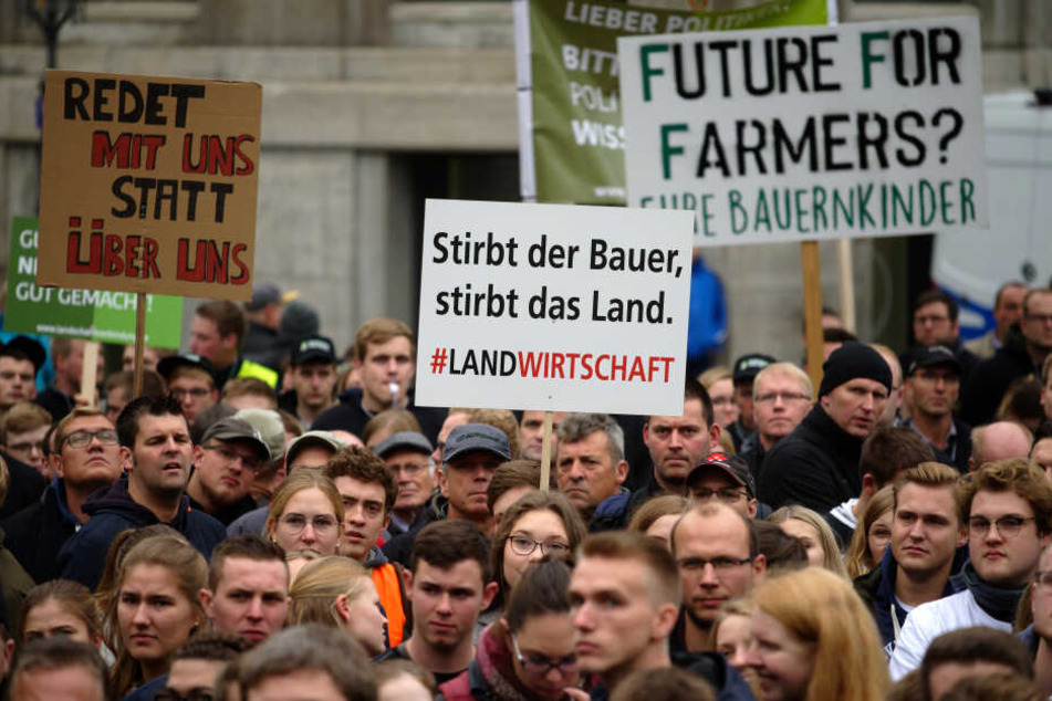 Teilnehmer halten auf dem Münsterplatz in der Bonner Innenstadt bei einer Demonstration gegen Agrarpläne der Bundesregierung Plakate hoch.
