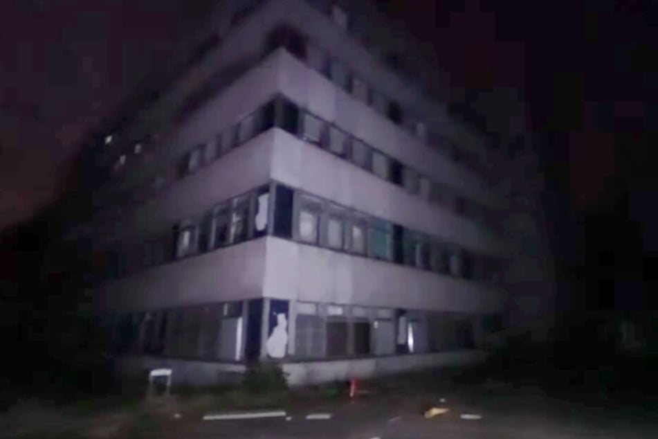 Das Krankenhaus von außen. Es steht verlassen am Rande eines Waldes.