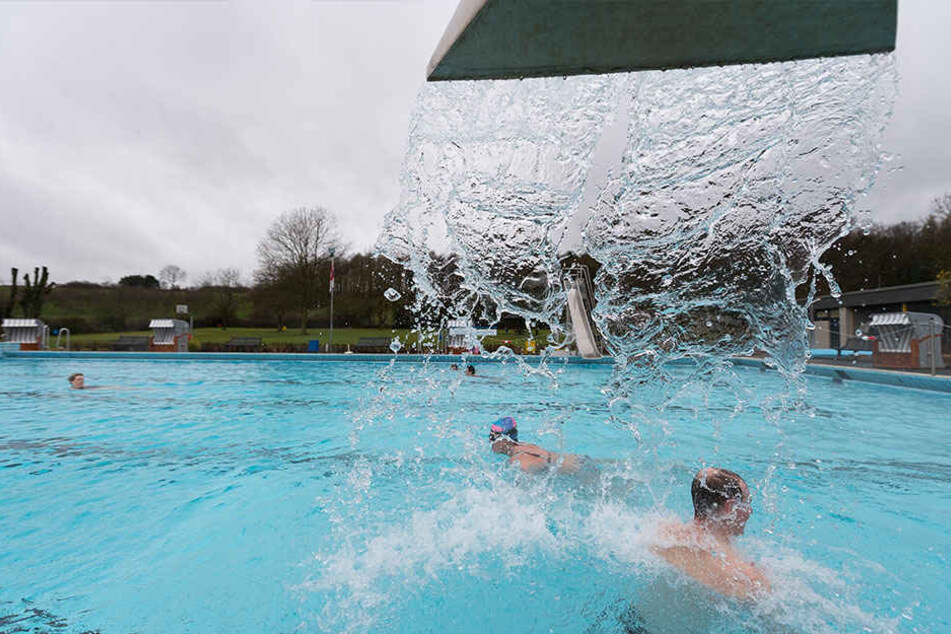 Ein Mann steht am Sonntag unter der Wasserdusche im Freibad Gaßbachtal in Oelde.