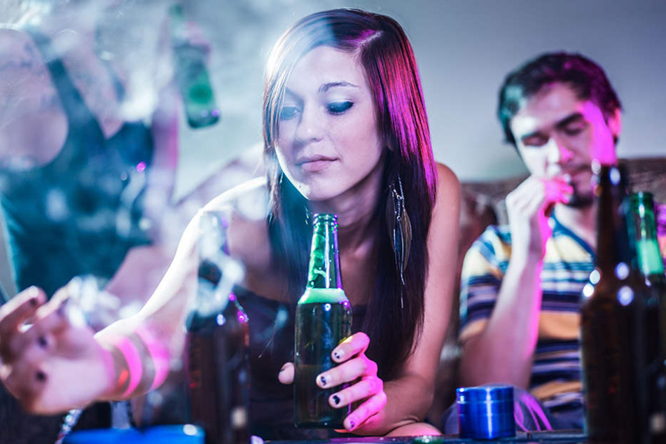 Ein Mädchen trinkt und raucht auf einer Party. Experten warnen: Erstkonsum beginnt immer mit legalen Drogen.