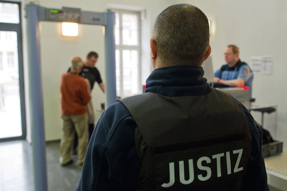 An einer Sicherheitskontrolle im Landgericht Potsdam überprüft ein Justizmitarbeiter einen Besucher.
