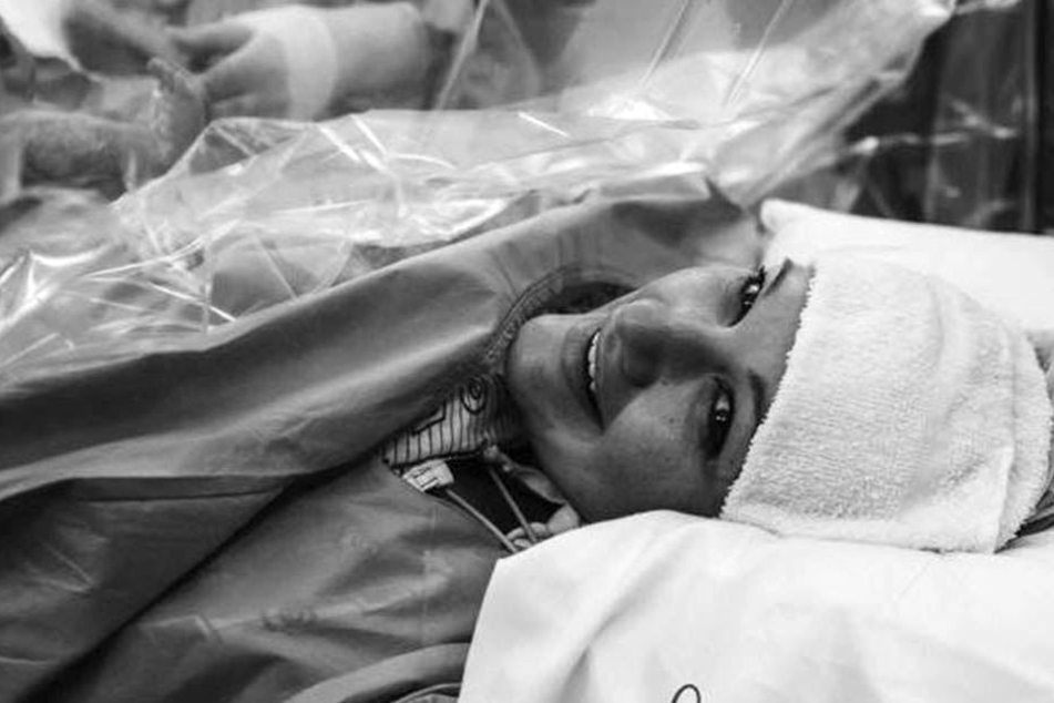 Überglücklich lächelt die Mutter nach der Geburt.