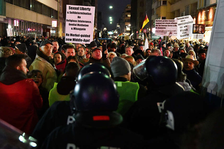 Polizisten stehen bei dem "Frauenmarsch" aus dem AfD-Umfeld nahe dem Checkpoint Charlie in einer Kette vor den rechten Demonstranten.