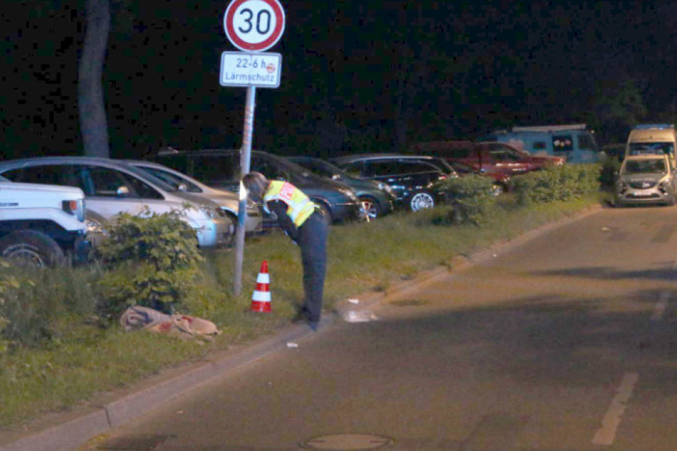 Eine Polizistin begutachtet das Straßenschild, gegen das der Fußgänger geschleudert wurde