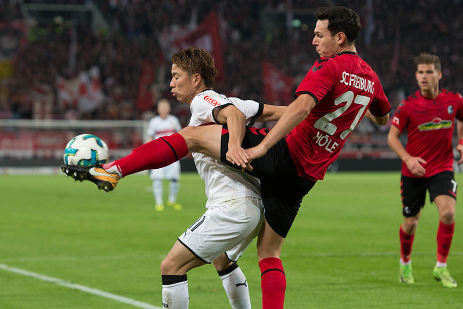 Takuma Asano (vorn) wehrt sich mit Leibeskräften gegen Niklas Höfler (hinten).