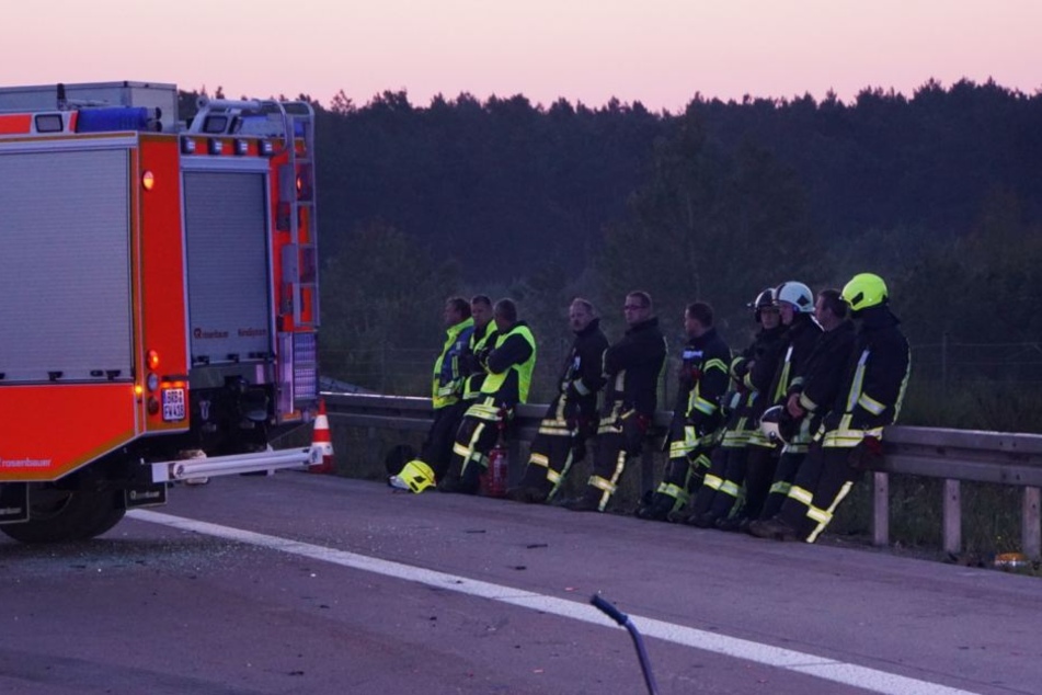 Die konsternierten Kollegen sitzend trauernd an der Leitplanke.