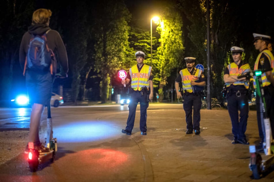 Polizisten kontrollieren einen E-Scooter-Fahrer.