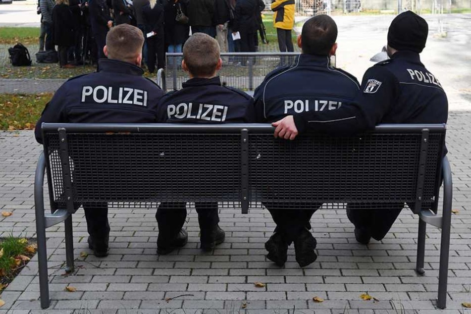 Polizeischüler sitzen auf dem Gelände der Akademie auf einer Bank.