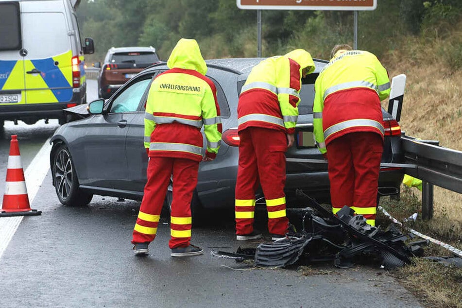 Mitarbeiter der Unfallforschung begutachten das gegen die Leitplanke gefahrene Fahrzeug.