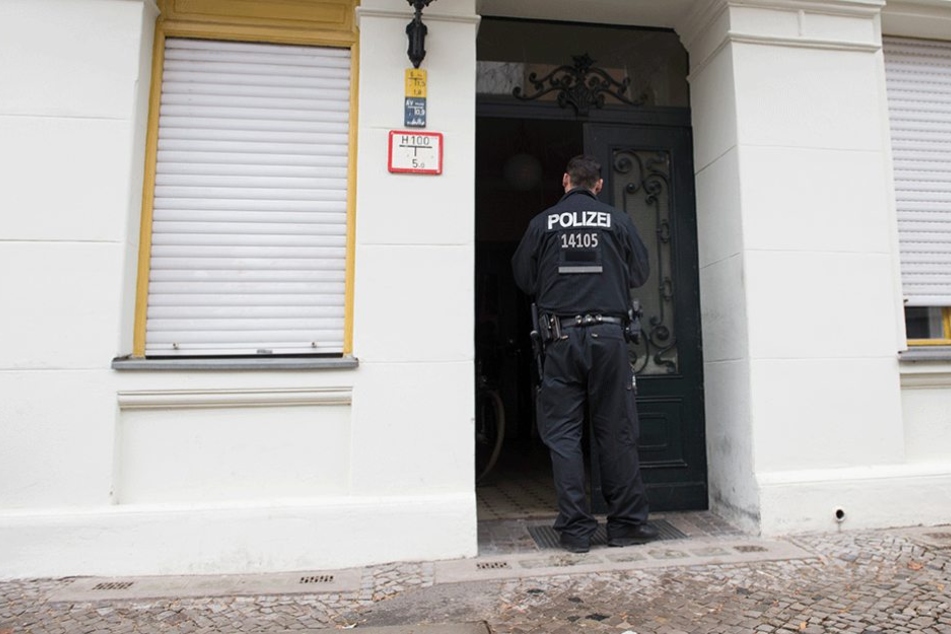 Ein Polizist steht im Eingang des Hauses, in dem die Bluttat geschah.