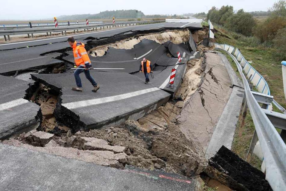Arbeiter an der kaputten Fahrbahn. Die Reparatur wird vermutlich Jahre dauern.