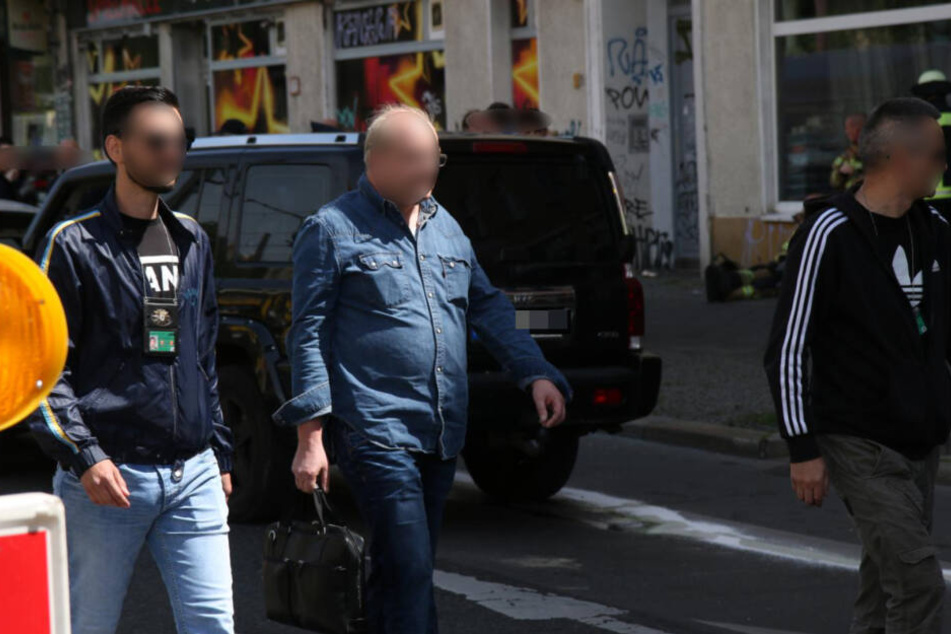 Der Verdächtige (Mitte) wird von Zivilpolizisten festgenommen, in der Hand hält er noch seine Aktentasche.