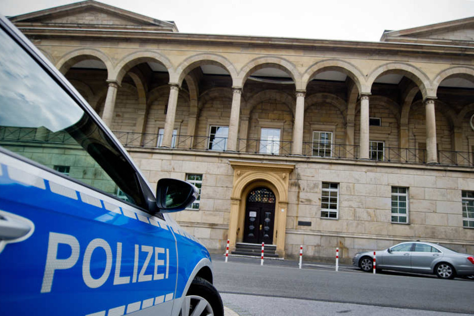 Ein Polizeifahrzeug steht vor dem Landgericht.