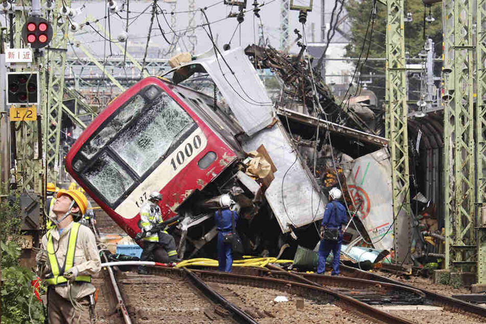 Der Zug steht entgleist nach einem Zusammenstoß mit einem Lastwagen an einem Bahnübergang auf den Gleisen.
