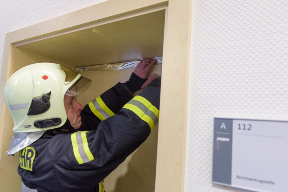 Ein Feuerwehrmann versiegelt eine Tür im Gericht.