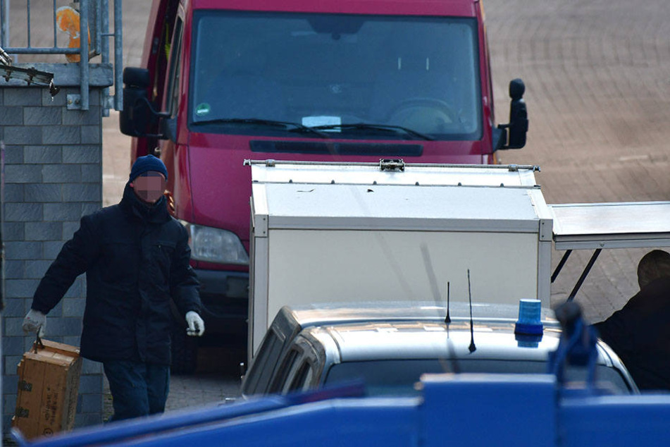 Polizisten verladen den Sprengstoff in speziellen Schutzbehältern, um ihn abzutransportieren.